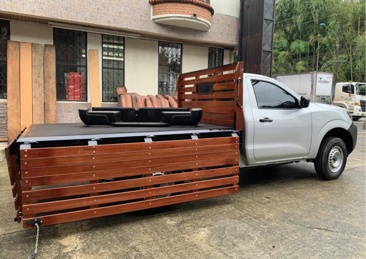 Camioneta gris con carrocería de estacas en madera