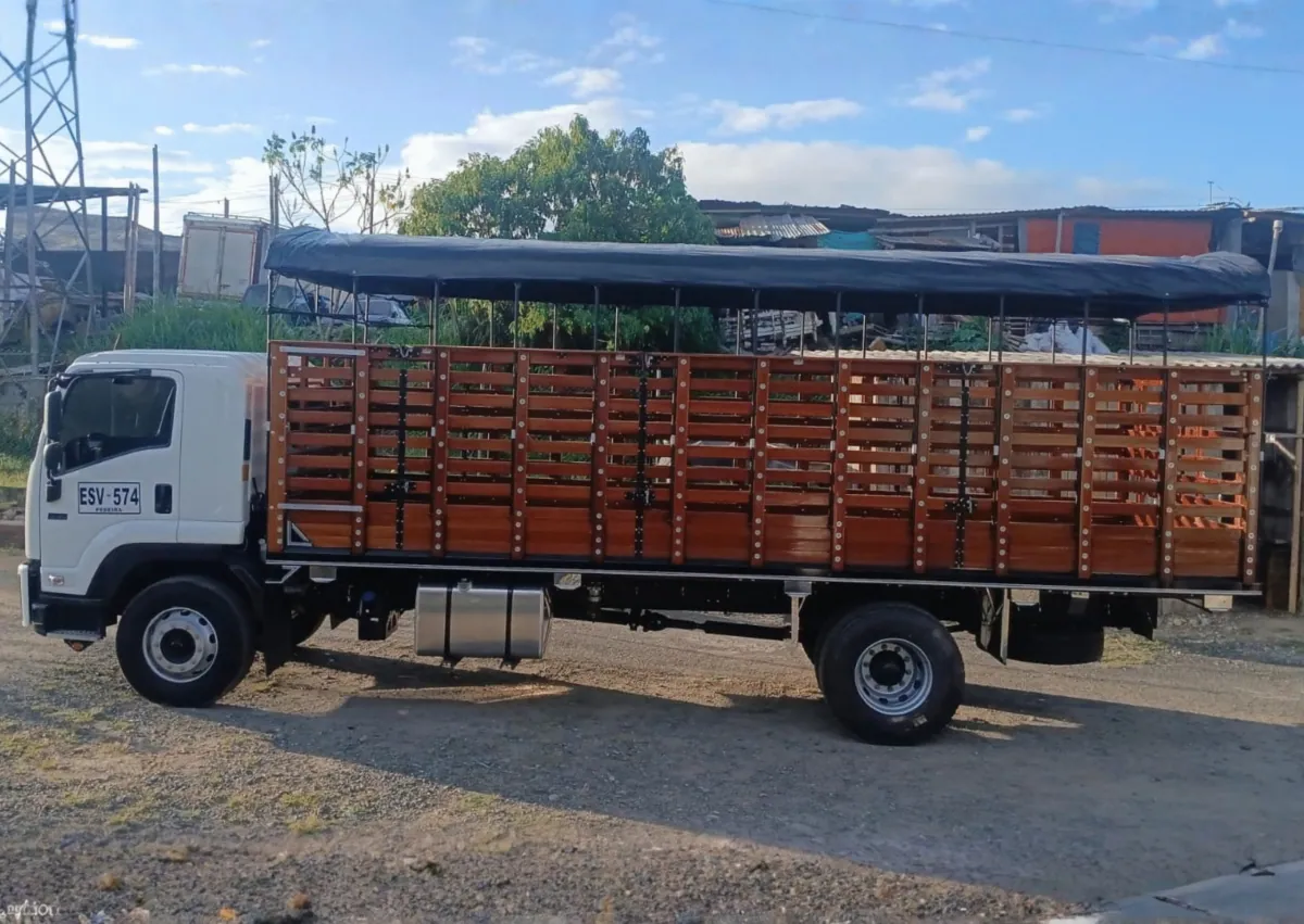 Camión con carrocería de estacas en madera y carpa azul