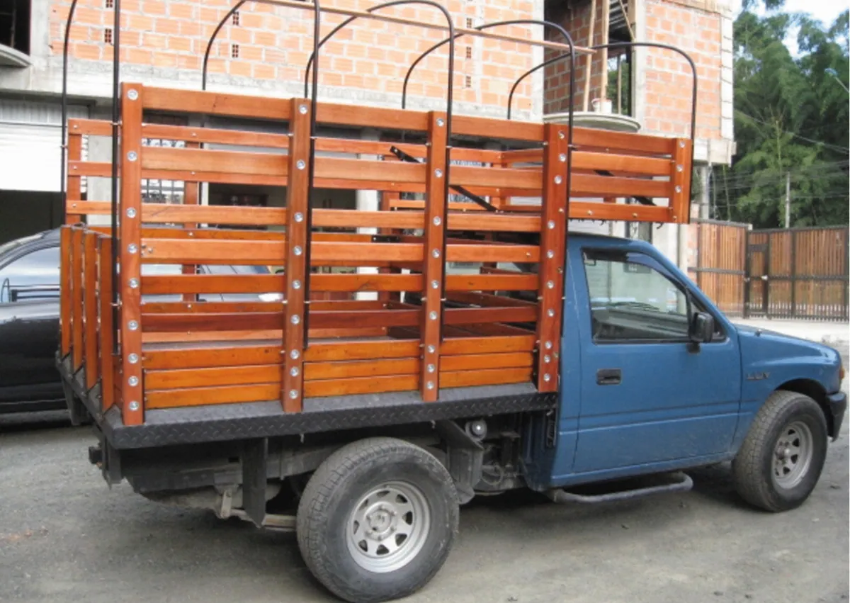 Camioneta azul con carrocería de estacas en madera