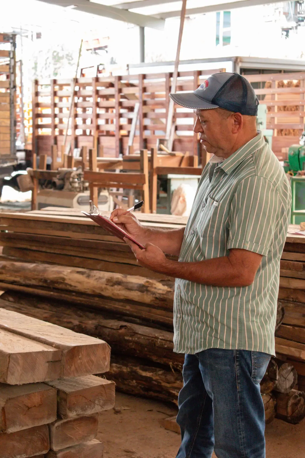 Supervisor revisando el inventario de madera en la planta