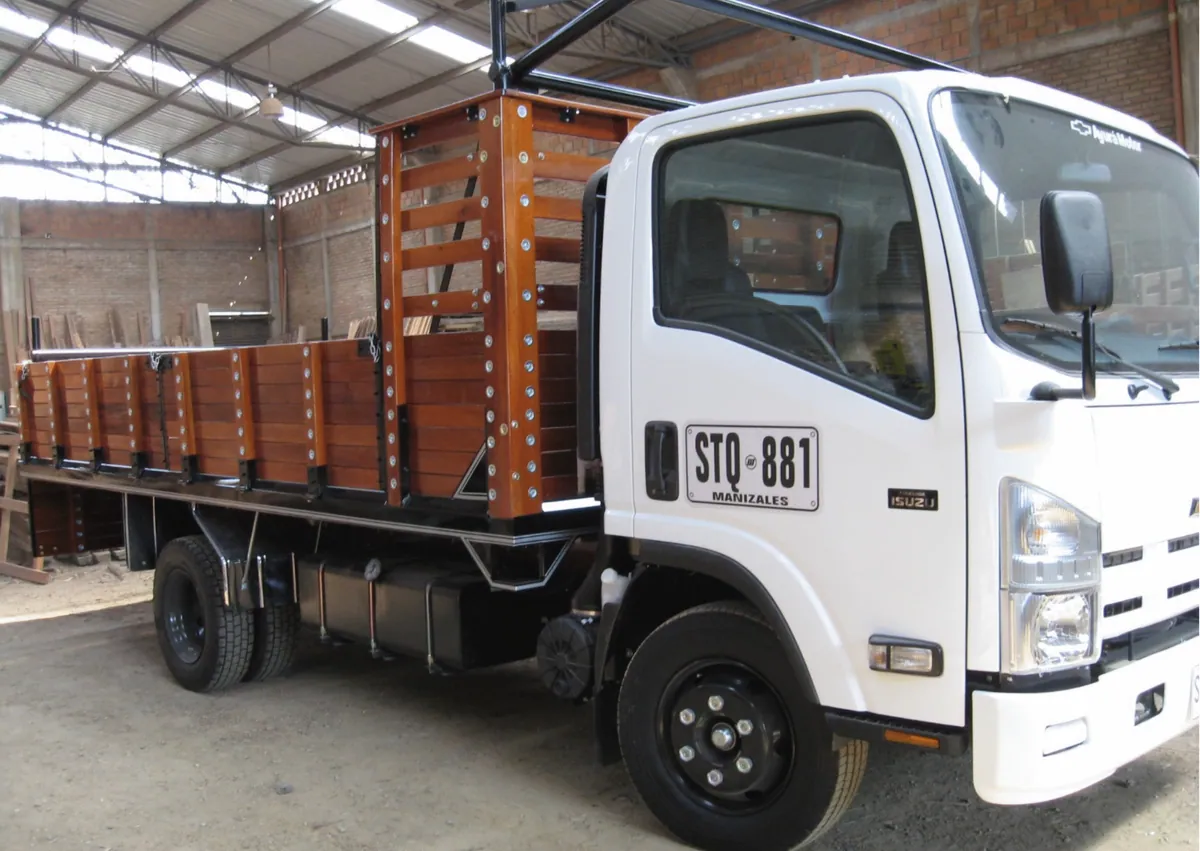 Camión blanco con carrocería tipo planchón en madera