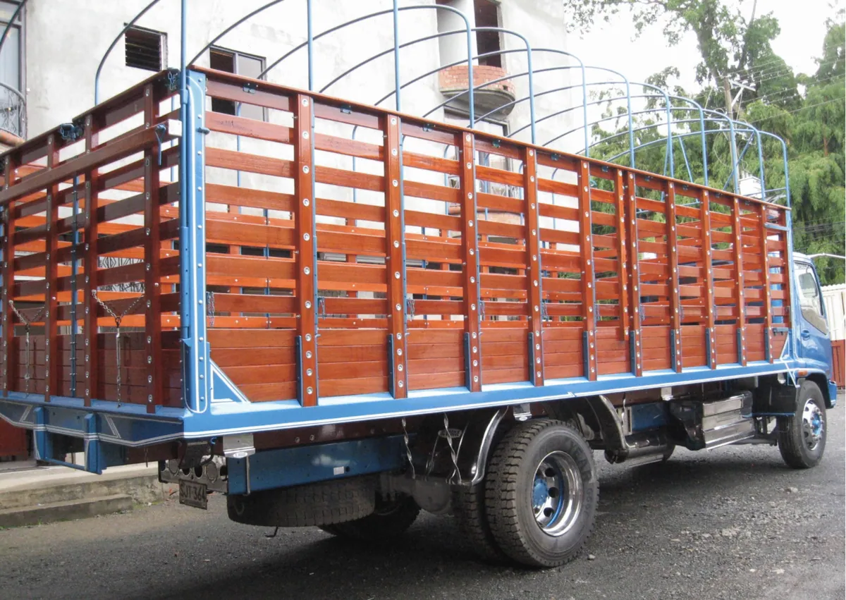 Camión con carrocería de estacas en madera y estructura azul