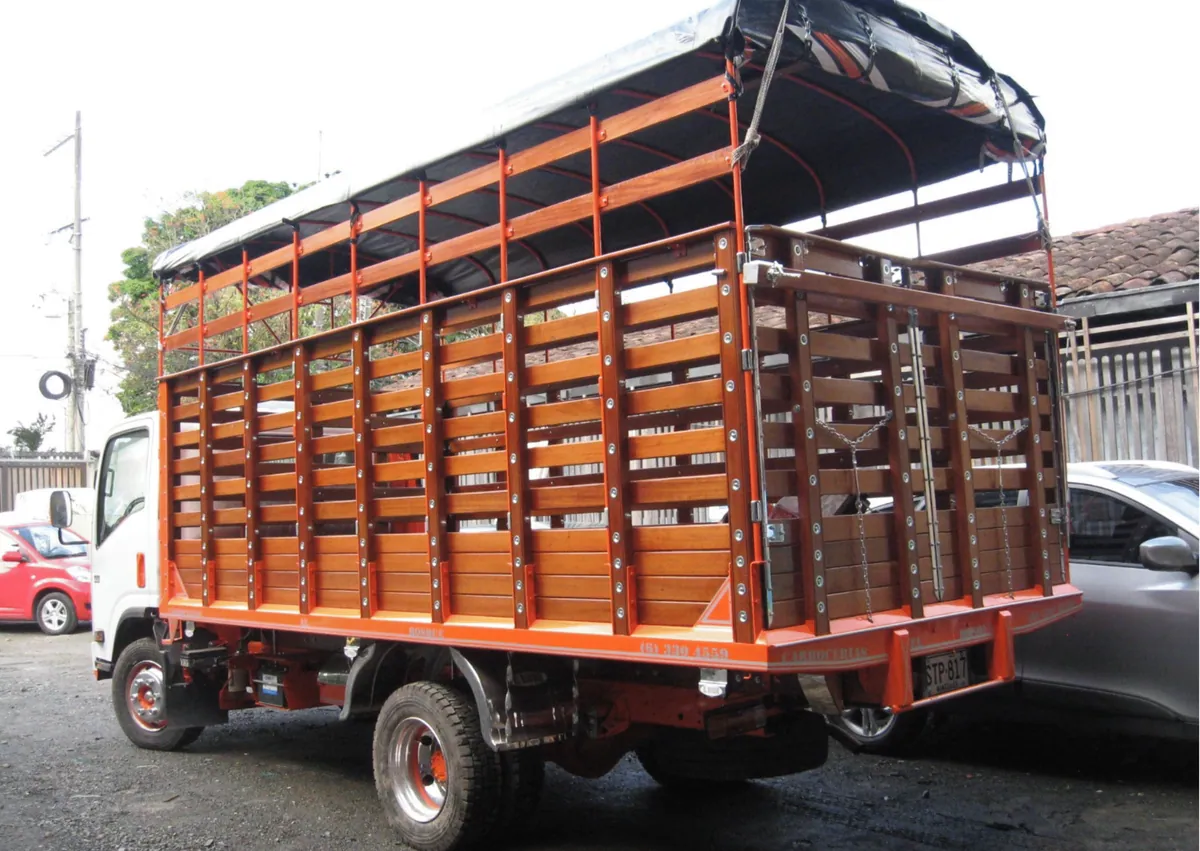 Camión con carrocería en madera, estructura naranja y carpa