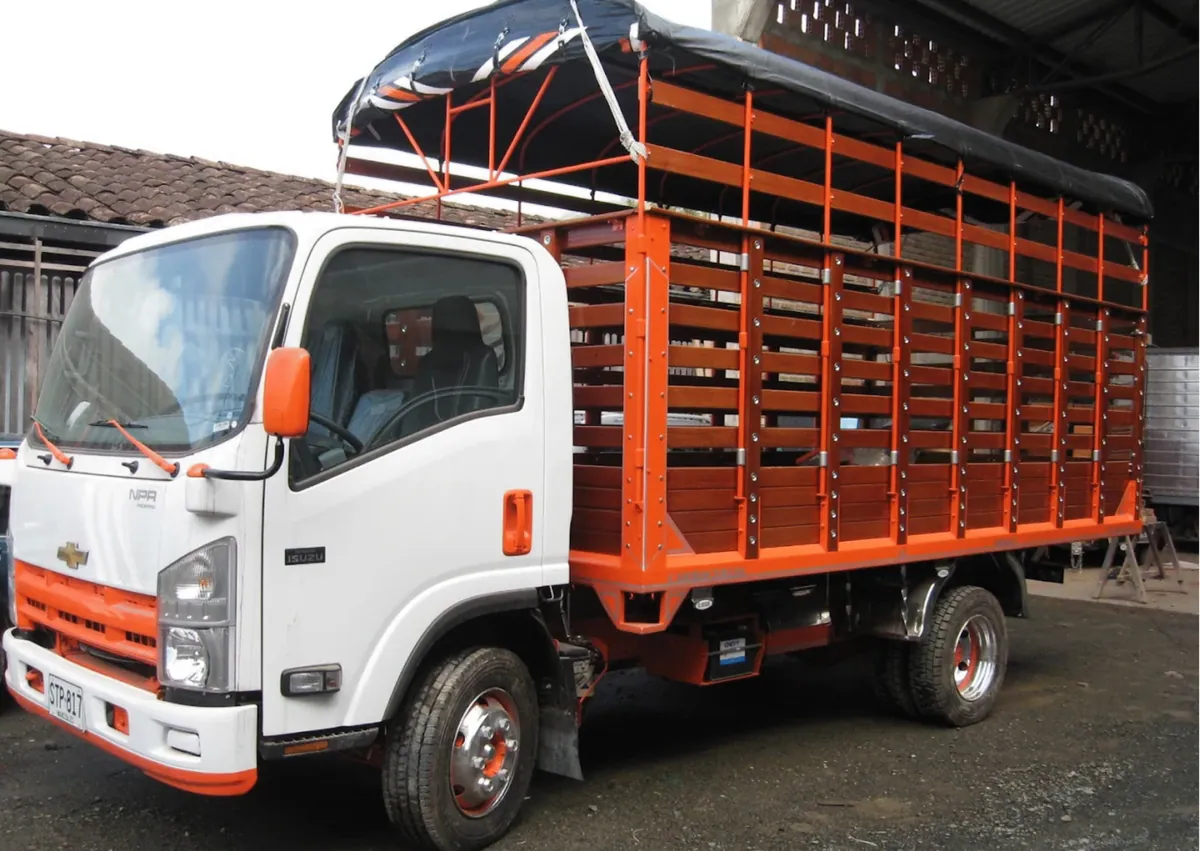 Camión blanco con carrocería en madera y estructura naranja