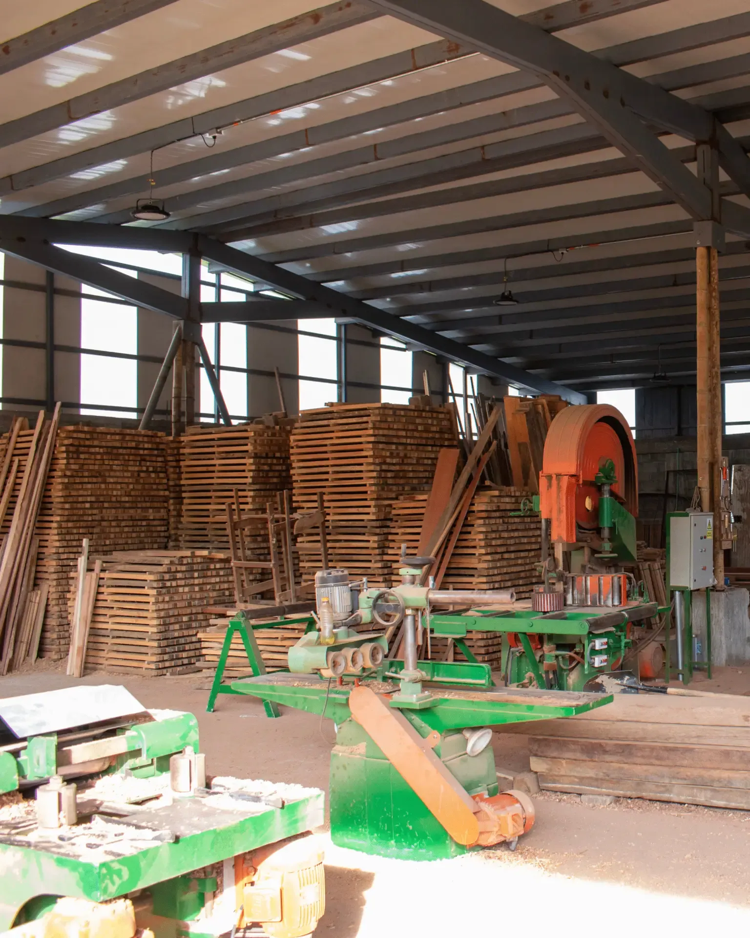Planta de producción con maquinaria y madera apilada